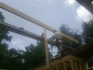 Carpenter setting a ridge beam over a new addition frame — Ice Dam Removal by Roofing Brothers in Roseville