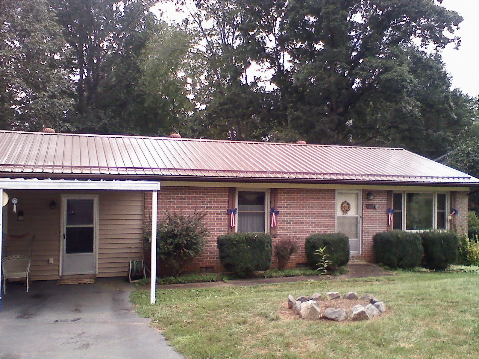 Bronze metal roof and carport on a brick ranch home — Roof Repair work by our crew in Roseville